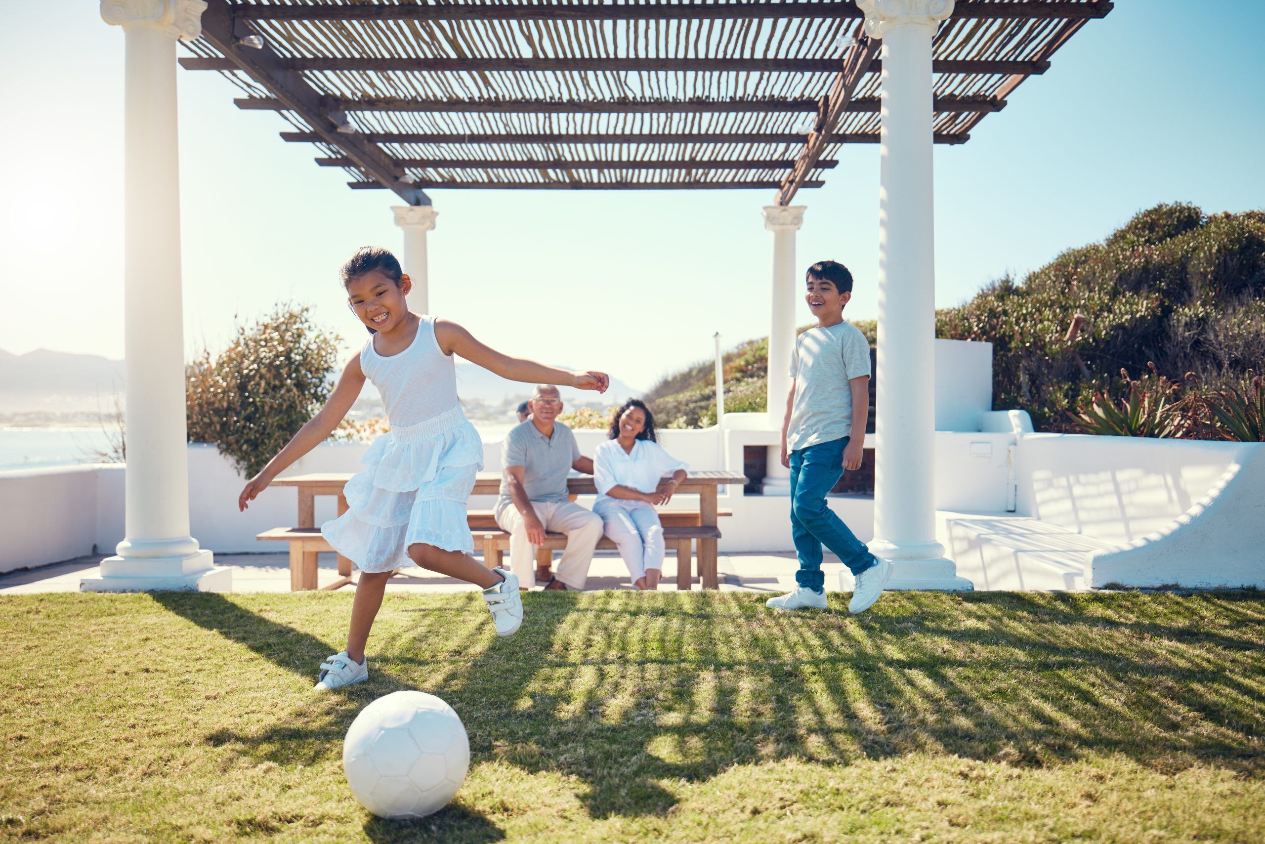 Family Vacation And Children Playing Soccer On