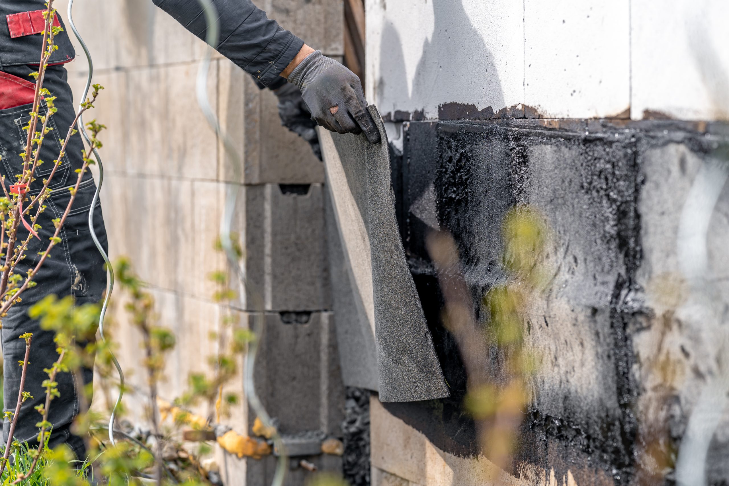 Installation Of Protective Waterproofing On The Foundation And Walls Of The Building. Warmed By An Open Fire
