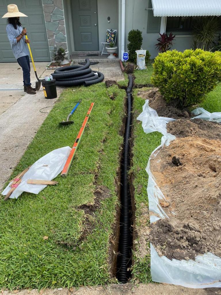 Team Member Digging Trench For Downspout Piping