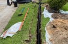 Team Member Digging Trench For Downspout Piping